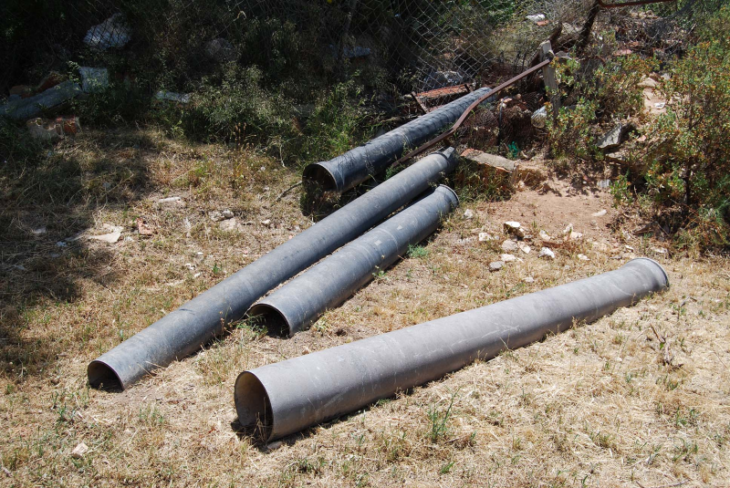 vallas de hierro, tuberías de agua, viga y pala elevadora 